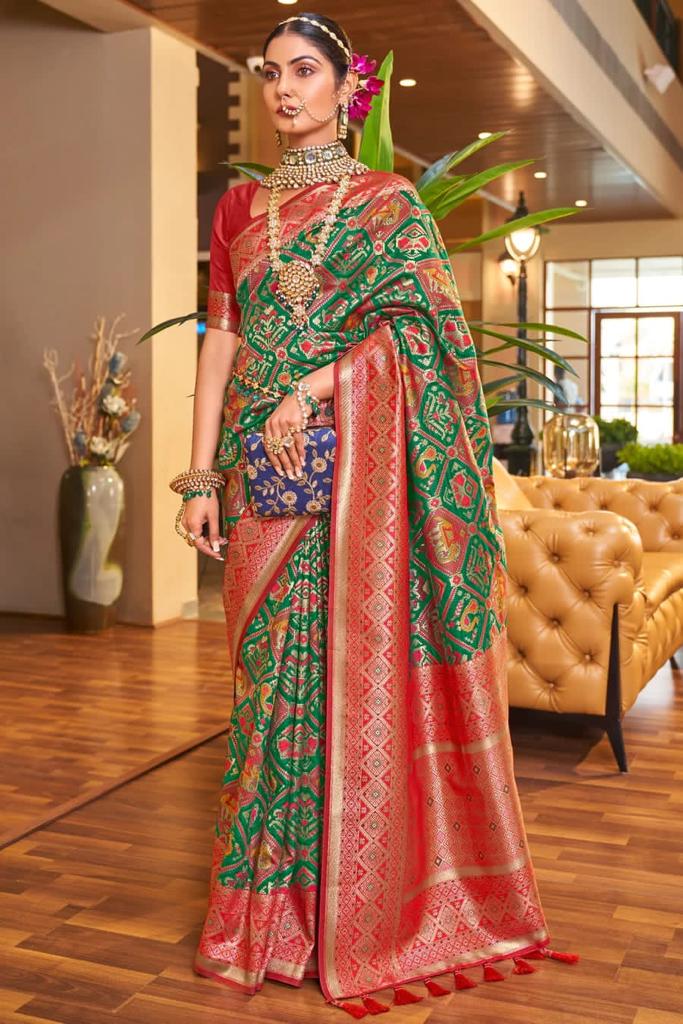 A dreamy Dark Green Patola Silk Saree with Super extravagant Blouse Piece