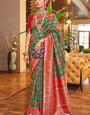 A dreamy Dark Green Patola Silk Saree with Super extravagant Blouse Piece