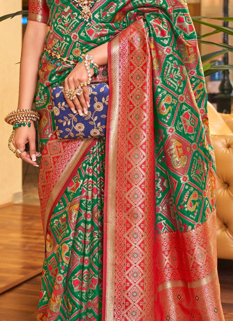 A dreamy Dark Green Patola Silk Saree with Super extravagant Blouse Piece