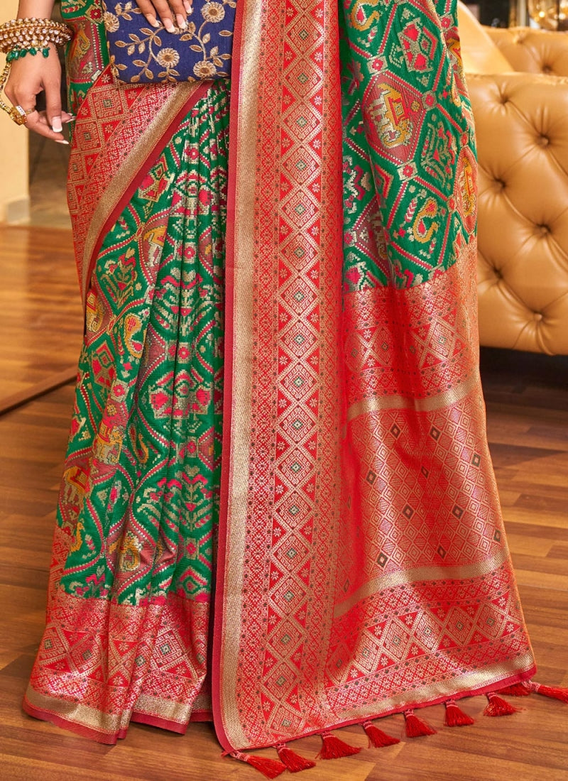 A dreamy Dark Green Patola Silk Saree with Super extravagant Blouse Piece