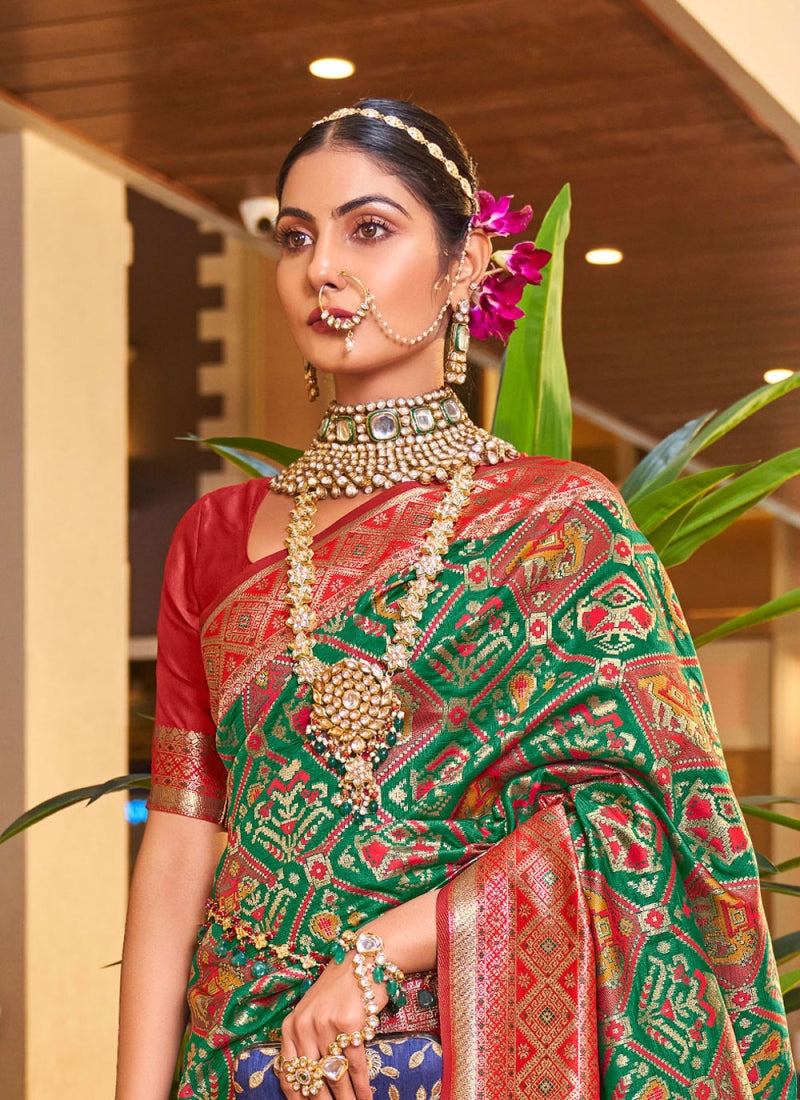 A dreamy Dark Green Patola Silk Saree with Super extravagant Blouse Piece